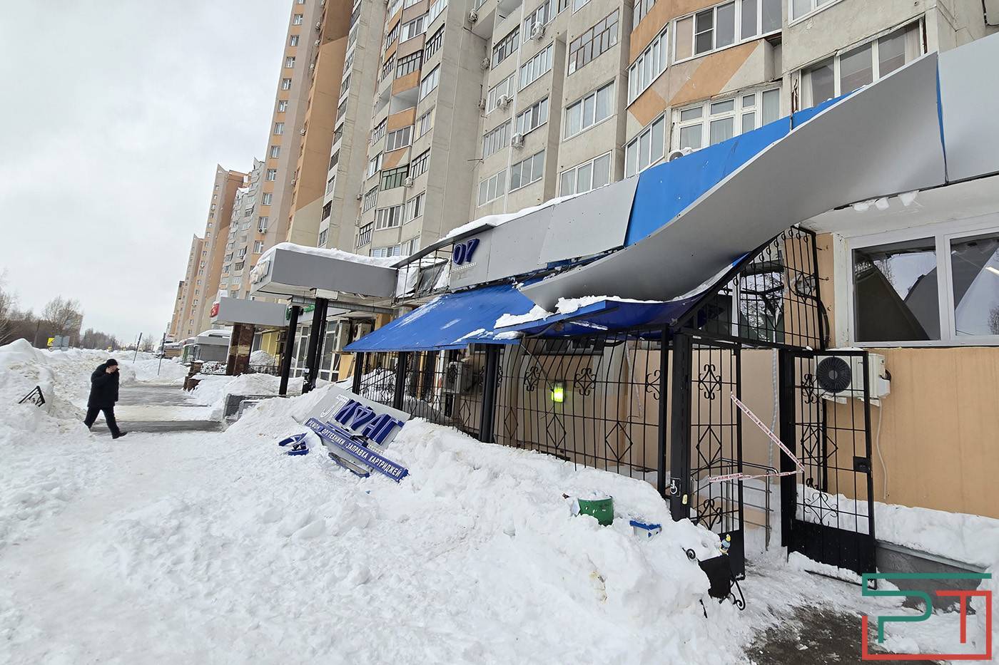Упавшие глыбы снега и льда сорвали вывески с дома по проспекту Победы в Казани - фото