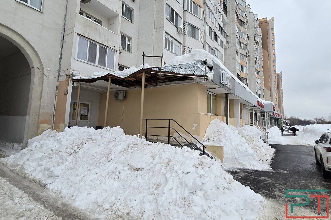 Упавшие глыбы снега и льда сорвали вывески с дома по проспекту Победы в Казани - фото