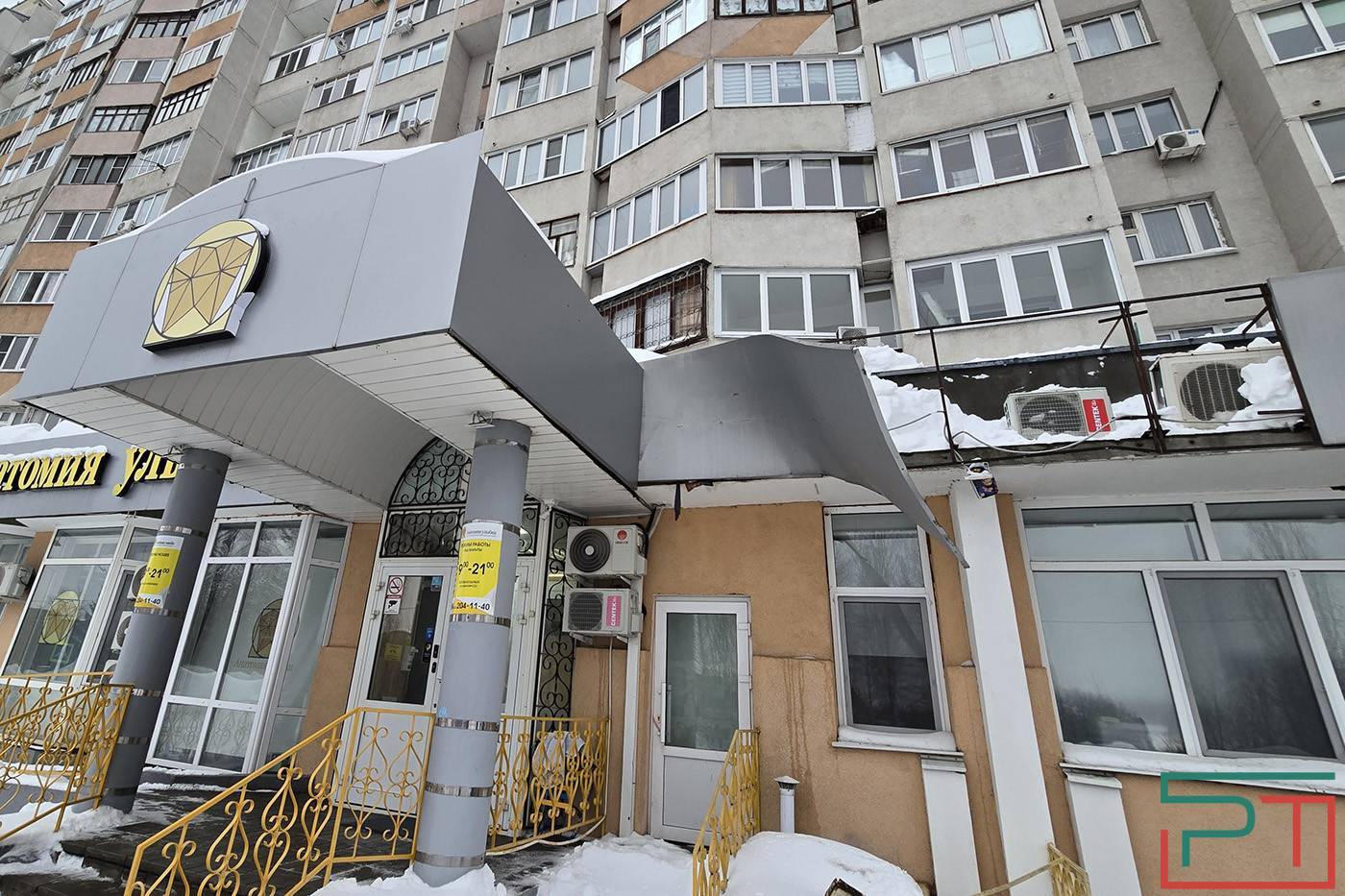 Упавшие глыбы снега и льда сорвали вывески с дома по проспекту Победы в Казани - фото