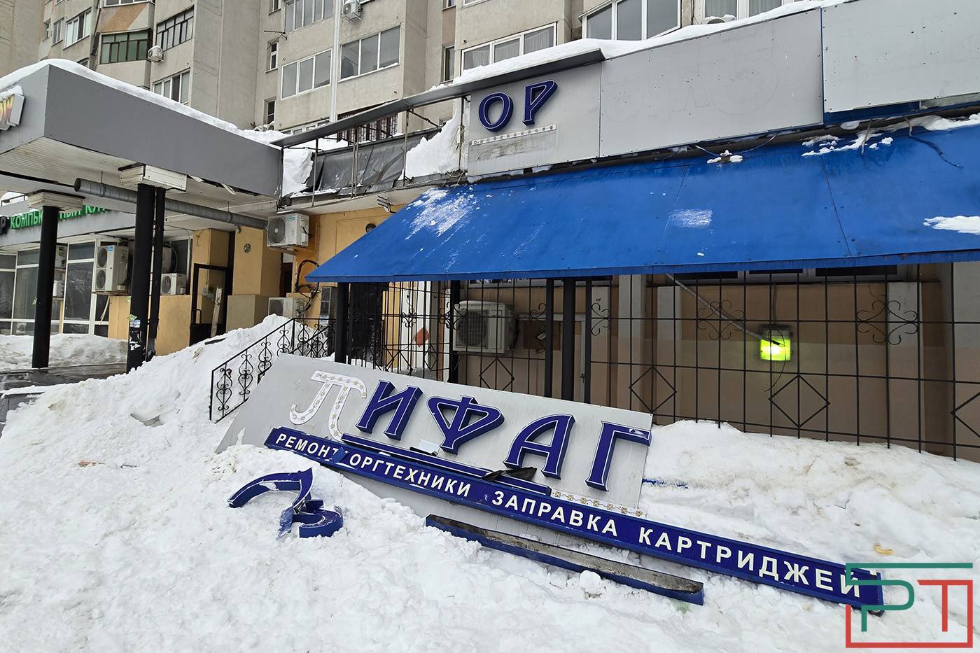 Упавшие глыбы снега и льда сорвали вывески с дома по проспекту Победы в Казани — фото