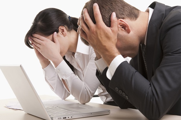 @Glowimages: Man and woman with heads in hands